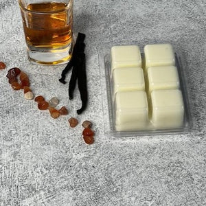 Wax melts are upside down displaying natural wax cubes. A shot of bourbon and vanilla next to it